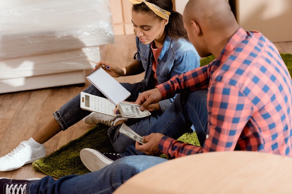 couple with money and calculator planning budget in new apartment